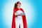 A doctor or nurse in medical gloves and a red superhero Cape on a blue background. Medical personnel during a coronavirus outbreak