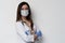 Doctor / nurse smiling behind surgeon mask. Closeup portrait of young caucasian woman model in white medical scrub