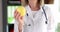 Doctor nutritionist holds yellow apple closeup