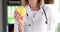 Doctor nutritionist holds yellow apple closeup