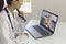 Doctor online consultation. Female doctor listens to an elderly patient uses a video call laptop.