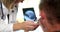 Doctor otorhinolaryngologist examining patient with otoscope on digital tablet closeup 4k movie slow motion