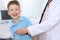 Doctor and patient in hospital. Happy little boy having fun while being examined with stethoscope. Healthcare and