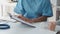 Doctor and patient sitting and talking at medical examination at hospital office, close-up. Therapist filling up medication