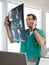 Doctor on Phone Discussing Patient\'s Spinal Scans