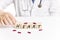 Doctor placing the word HEART with wooden cubes next to pills