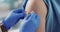 Doctor, plaster and hands on patient arm for vaccine and healthcare and wellness by injection. Nurse, bandage and