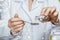 A doctor is pouring some medicine from the bottle into the spoon with the medical icons and symbols system at the foreground