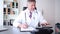 Doctor or practitioner with digital tablet while writing notes