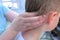 Doctor professional massagist makes head massage to teen boy in clinic, closeup.