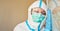 Doctor in protective clothing with eyes closed due to exhaustion from coronavirus pandemic