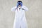 A doctor in protective clothing grabs his head