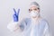 Doctor in protective gown shows the victory and peace sign. Defeating the virus. White background