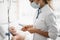 Doctor in protective mask checking intravenous drip in hospital room