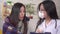 Doctor in a protective medical mask interviews a sick asian woman close up