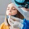 Doctor in protective medical mask taking PCR test nasopharyngeal culture to woman. Diagnostics testing patients coronavirus covid