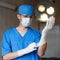 Doctor puts a glove on his hand. Surgeon preparing for surgery