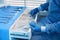 Doctor putting medical clamps into drawer, closeup. Table with different surgical instruments