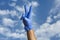 Doctor raised hand with victory sign, happy excited good positive doctor wearing blue medical glove raising hand up feeling