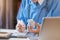 Doctor reading on a document report and writing on paperwork and searching treatment information at office.