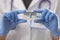 Doctor in rubber gloves holding blister blue capsule close-up