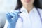 Doctor in rubber gloves holding syringe with medicine closeup