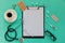 Doctor`s desk top view. Stethoscope, pills, glasses and notebook on a colored background