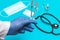 Doctor`s hand in a white coat and blue sterilized surgical glove holding two empty insulin syringes, blurred background with