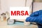 Doctor's hands in blue gloves shows the word MRSA Medical concept