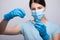 Doctor scientis in protective gloves and mask holding glass vial with injection liquid. Vaccination against influenza and