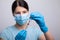 Doctor scientis in protective gloves and mask holding glass vial with injection liquid. Vaccination against influenza and