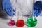 Doctor Scientist Shows Colored Chemical Flasks - Labs Photo