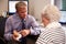 Doctor Showing Senior Female Patient Model Of Human Ear