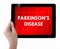 Doctor showing tablet with PARKINSONS DISEASE text.