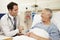 Doctor Sitting By Male Patient\'s Bed In Hospital