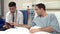 Doctor Sitting By Man\'s Bed In Hospital With Digital Tablet