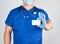doctor in sterile latex gloves and blue uniform holds a blank white business card