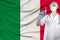 Doctor with a stethoscope on the background of the silk national flag of italy holding a medical syringe for injection, the