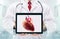 Doctor with stethoscope in a hospital. Heart on the tablet