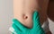 A doctor surgeon in medical gloves examines the abdomen of a newborn baby with an enlarged umbilical ring and an