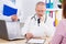 Doctor at the table examines the results of his patient`s analyzes, doc in medical office