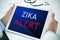 Doctor with a tablet with the text zika alert