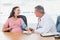 Doctor taking blood pressure of smiling pregnant patient