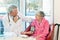 Doctor taking an elderly womans blood pressure.