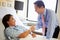 Doctor Talking To Female Patient On Ward