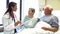 Doctor Talking To Senior Couple In Hospital Room