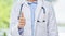 Doctor, thumbs up and hand of a medical employee, thank you healthcare gesture against blurred background. Hands of a
