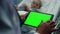 Doctor touching tablet green screen closeup. Sick girl lying in hospital bed.
