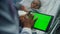 Doctor touching tablet green screen closeup. Sick girl lying in hospital bed.