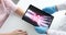 Doctor traumatologist holding digital tablet with xray near patient hand closeup 4k movie slow motion